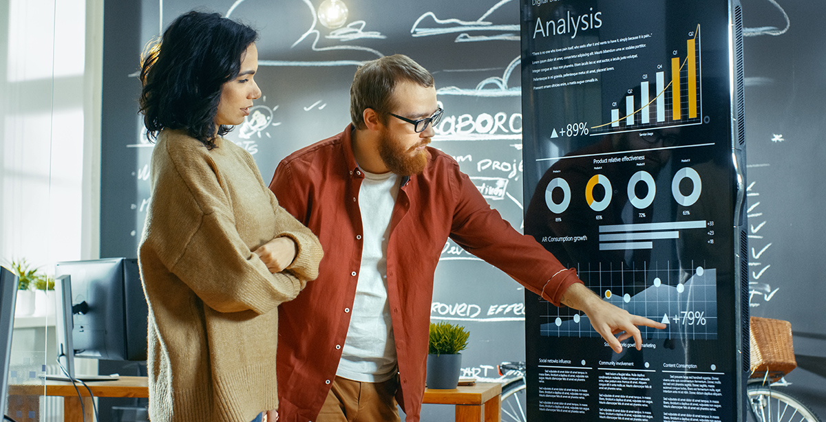man training woman on interactive touchscreen